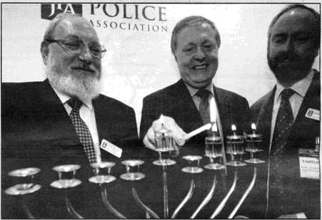 Rabbi Plancey, Sir Ian Blair and Rabbi Romain light the menorah