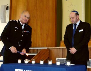 Commissioner lighting a candle with Mathew Shaer, chair of the Jewish Police Association